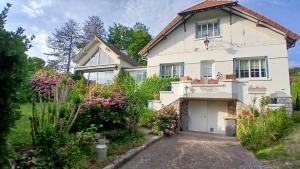 a large white house with a driveway at Le chant des roses in Giverny +30 photos