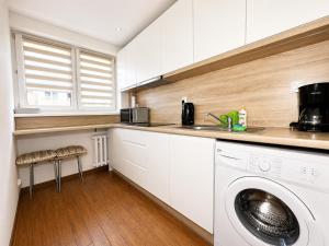 a kitchen with a sink and a washing machine at Apartament Wisła Centrum in Wisła
