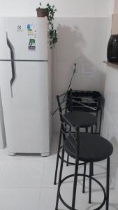 a black chair sitting next to a refrigerator at Cantinho da Alzira - Sobrado in Iguaba Grande