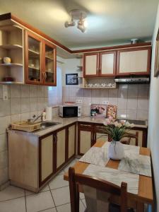 a kitchen with wooden cabinets and a table with flowers on it at Horváth kuckó in Fonyód