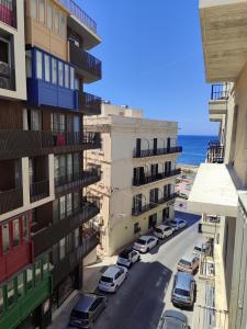 a view of a street with buildings and the ocean at Blue bay Sliema in Sliema