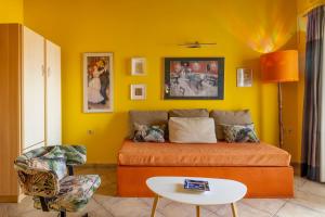 a yellow living room with a couch and a table at Villa Kirki Apartments in Agia Effimia