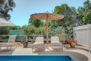 a patio with chairs and an umbrella next to a pool at THE SPOT GLAMPING STUDIOS PROTARAs in Paralimni