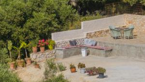 a patio with a table and chairs and potted plants at Villa Mimoza Apelati in Keri