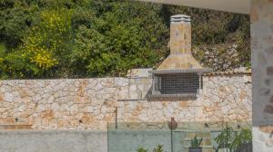 a stone wall with a chimney on top of it at Villa Mimoza Apelati in Keri +18 photos