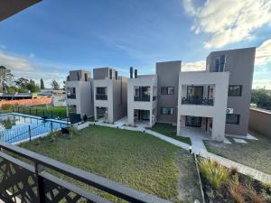 a large white building with a pool in front of it at Aires de Laguna in Chascomús