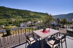 a table and chairs on a balcony with a view at Wohnen am Weingut - Auf dem Ausguck in Briedel