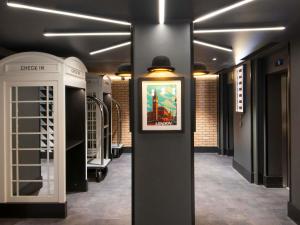 a room with a painting on the wall and a wall at ibis Styles London Gatwick Airport in Crawley