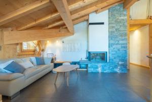 a living room with a couch and a stone fireplace at Appartement Corniche - MultiPass in Les Gets