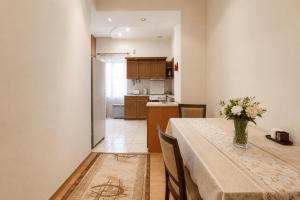 a kitchen and a table with a vase of flowers on it at Large apartment by the Opera- luxury living room, 2 bedrooms, equipped kitchen and balcony in Yerevan