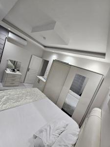 a white room with a bed and a mirror at Paradise Garden sitesi 3 oda havuzlu eşyalı daire kişi fiyatı değil oda fiyatı in Side