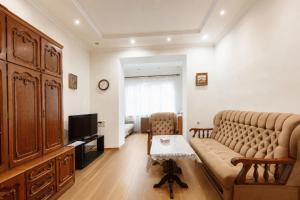 a living room with a couch and a television at Large apartment by the Opera- luxury living room, 2 bedrooms, equipped kitchen and balcony in Yerevan