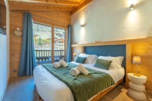 a bedroom with a large bed with a large window at Appartement Corniche - MultiPass in Les Gets