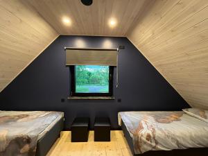 two beds in a room with a window at Mihkliranna Puhkemaja in Marksa