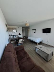 a living room with a couch and a bed and a table at Zenao Appart's Yzeure in Yzeure