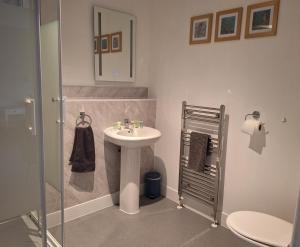 a bathroom with a sink and a shower and a toilet at Care Ashore Guest Rooms in Cranleigh +43 photos