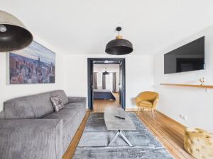 a living room with a couch and a table at Arden Suites Hébergements à thème in Charleville-Mézières