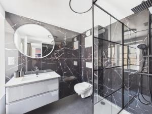 a bathroom with a toilet and a mirror at Arden Suites Hébergements à thème in Charleville-Mézières