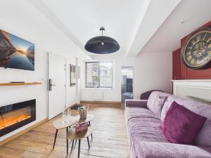 a living room with a couch and a fireplace at Arden Suites Hébergements à thème in Charleville-Mézières +30 photos