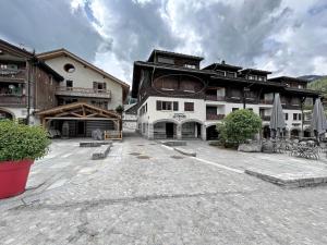 a large building with a courtyard in front of it at CAPRICE 4 - Appartement centre village et proche pistes in La Clusaz