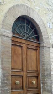 a large wooden door in a stone building at Residenza I Due Mondi in Spoleto