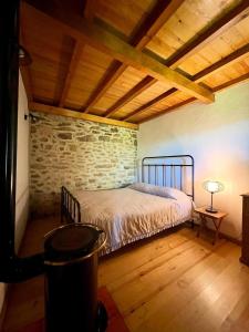 a bedroom with a bed and a brick wall at Aveleira EcoCasa in Melgaço