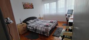 a bedroom with a bed and a desk with a computer at Apartman Ograde in Bosanski Novi