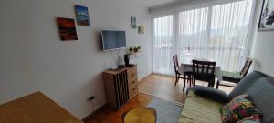 a living room with a couch and a dining room table at Apartman Ograde in Bosanski Novi