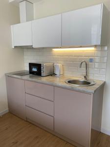 a kitchen counter with a sink and a microwave at Coastal Breeze Apartment in Batumi