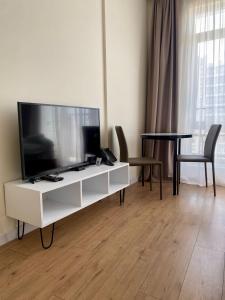 a living room with a large tv and a table at Coastal Breeze Apartment in Batumi