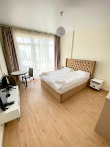 a bedroom with a bed and a desk and a table at Coastal Breeze Apartment in Batumi +8 photos