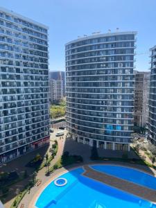 an aerial view of two tall buildings with a swimming pool at Coastal Breeze Apartment in Batumi