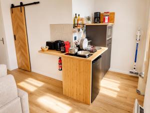 a small kitchen with a counter and a stove at MRODBNB - Appart Neuf - Aperçu Mer - 25m Plage & Resto - Ciné - cheminée - Popcorn in Cancale +11 photos