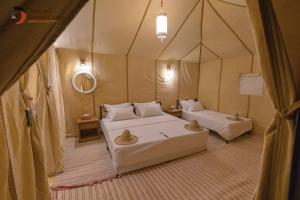 a room with two beds in a tent at Original Desert Camp in Merzouga +93 photos