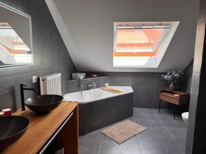 a bathroom with a sink and a bath tub at hirsch APARTEMENTS in Rheine +39 photos
