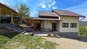 a house with a porch and a patio at La Murmur de Padure in Bălnaca