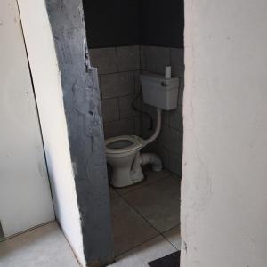 a bathroom with a toilet in a small room at Prime Guest Inn in Benoni
