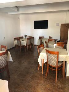 a dining room with tables and chairs and a flat screen tv at Pensiunea Diskret in Sovata