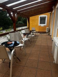 a group of chairs and tables on a patio at Áldos Panzió in Farád