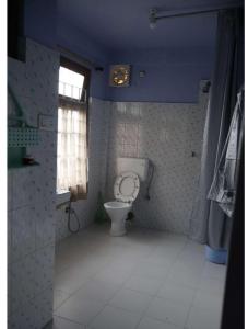 a bathroom with a toilet and a window at Ang Ds Homestay in Sonāda