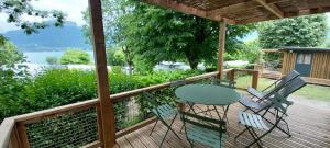 a patio with a table and chairs on a deck at Camping Onlycamp Au Cœur du Lac - Lac d'Annecy in Sévrier