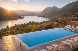 a swimming pool with chairs and a view of a lake at Lake View 49 in Sale Marasino