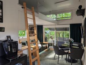 a room with a loft bed and a dining room at Tinyhouse Nelson in Papenburg +2 photos