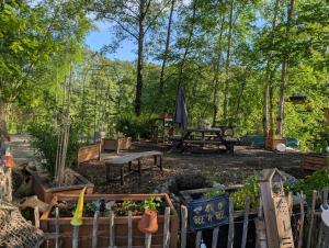 a garden with a picnic table and benches at Tinyhouse Nelson in Papenburg