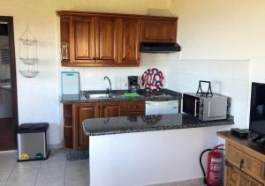 a kitchen with wooden cabinets and a counter top at Bella Vista - Finca Tabaiba in Icod de los Vinos