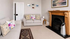a living room with a couch and a fireplace at Govandale Seaviews in Kingarth