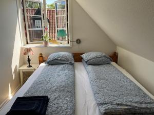 a bed in a room with a window at Boots and Bikes B&B in Neksø