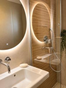 a bathroom with a shower with a sink and a tub at Pension Anastasia in Ammouliani