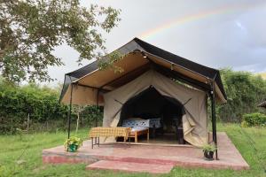 a tent with a table and a chair in it at Elephant trails camp in Sekenani