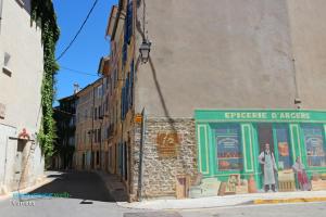 a street with a building with a green storefront at Studio Agave in Correns +6 photos